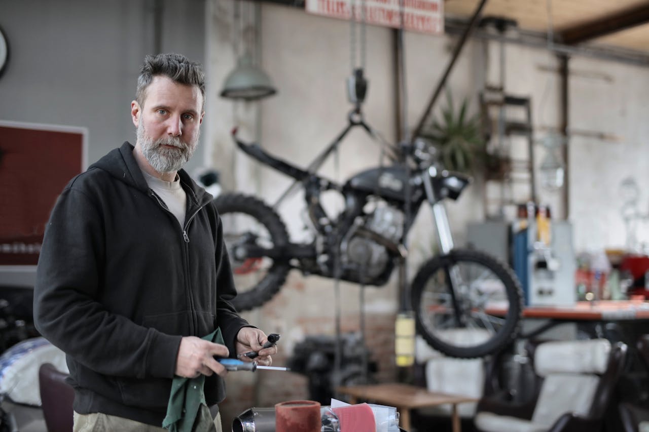 A skilled mechanic works with tools in a contemporary motorcycle repair shop.