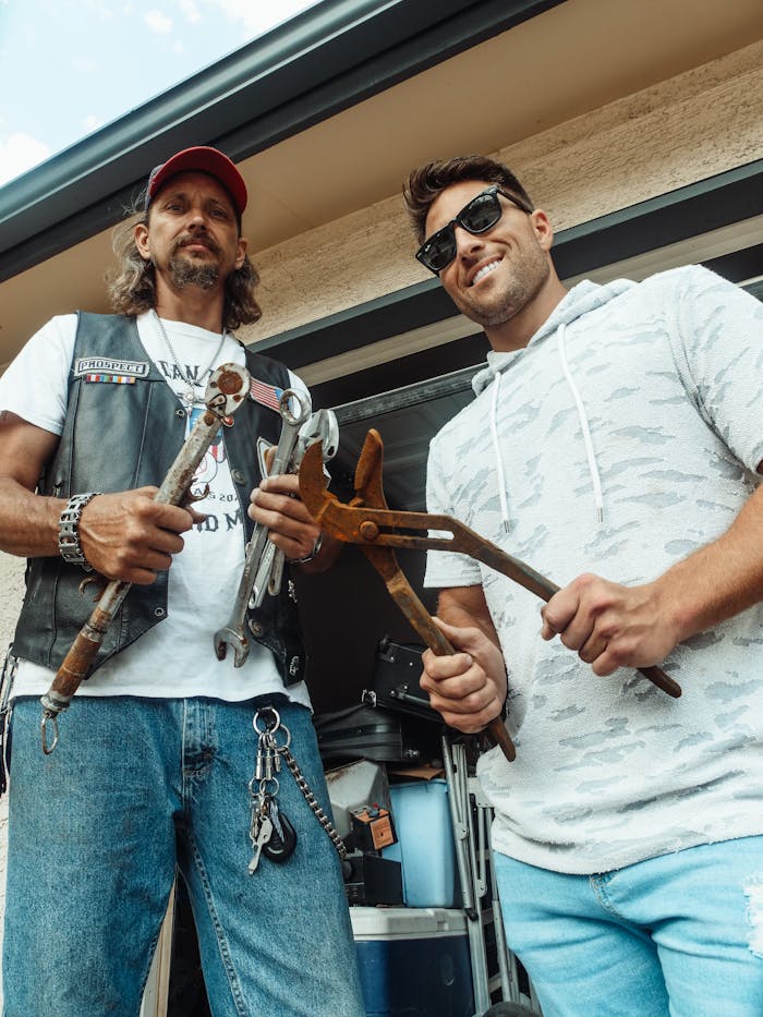 A father and son bond while repairing a motorcycle, showcasing tools and teamwork in a garage setting.